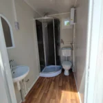 Office container bathroom equipped with a shower, toilet and washbasin to improve comfort for employees on site.